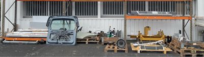un camion garé devant un bâtiment, chargé de nombreuses palettes