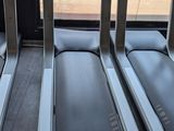 three tread machines are lined up in a row in front of a window