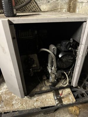 a dirty furnace with a hose in the middle of it