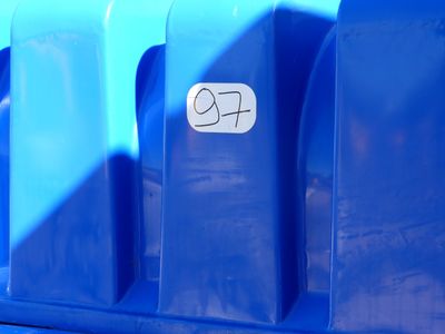 a blue trash can with a sticker on the side of it