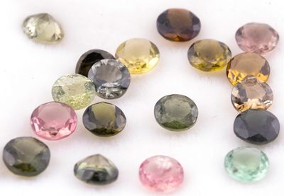 plusieurs pierres précieuses de différentes couleurs sur une surface blanche, avec un fond blanc