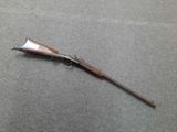 an old rifle with a wooden handle on a gray surface