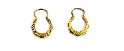 two pairs of gold earrings on a white surface with a white background
