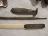 a knife, knife sharper, and other silverware on a table