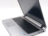 a silver laptop with a black keyboard on a white surface