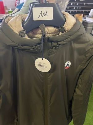 a green jacket hanging on a hanger in a store