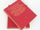 two books sitting on top of each other on a white surface