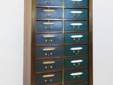 a tall wooden cabinet with many drawers on it