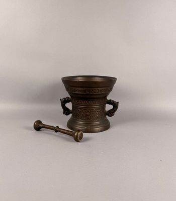 mortier et pilon en laiton ancien sur fond blanc