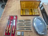 a wooden table with silverware and knives on it