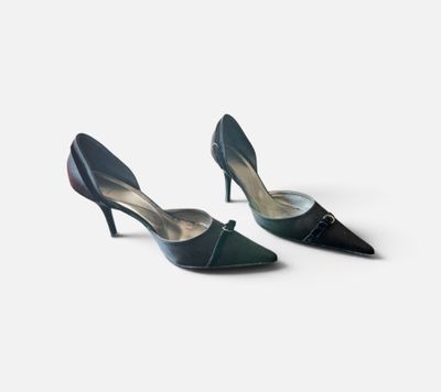 une paire de chaussures noires à talons hauts sur une surface blanche