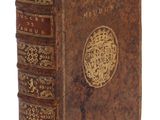 un vieux livre dont la couverture est ornée d'un motif doré