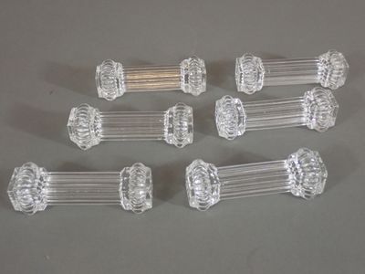 six clear glass door knobs on a gray surface