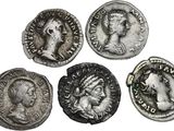 quatre pièces de monnaie romaines anciennes, dont l'une représente la tête d'une femme et une autre une tête