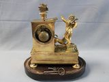 a gold clock with a statue on top of it