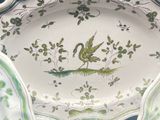 a plate with a bird on it and a bowl with a bird on it