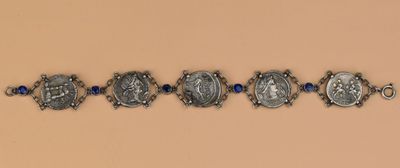 un gros plan sur une rangée de bracelets en argent ornés de perles bleues