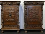 paire d'armoires anciennes en bois sculpté, ornées d'une tête de lion sur la porte