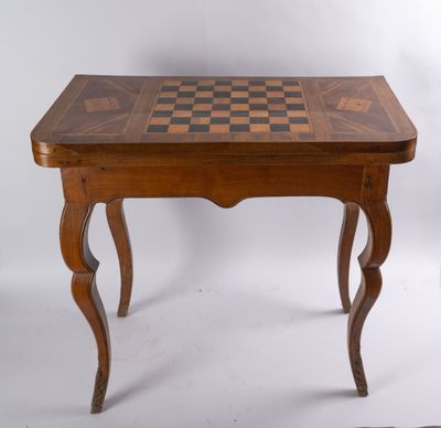 une vieille table en bois sur laquelle est posé un échiquier