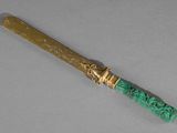 un couteau doré et vert avec un manche vert