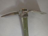 a metal hammer with a green handle on a white surface