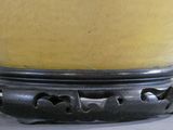 a yellow vase that is sitting on a stand
