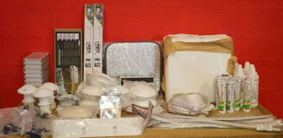 de nombreux objets posés sur une table, avec un mur rouge en arrière-plan