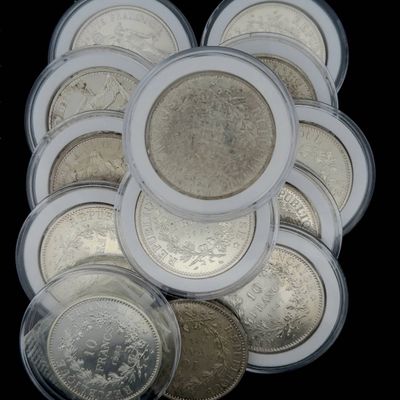 beaucoup de pièces de monnaie dans un récipient en plastique posé sur une table
