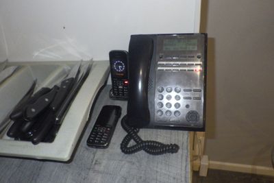 un téléphone noir posé sur un comptoir, à côté d'un autre téléphone