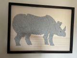 une photo d'une photo d'un rhinocéros accrochée au mur