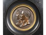 médaillon en bronze représentant un homme et une femme de profil sur fond noir
