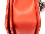 an orange purse with a chain hanging from it ' s side