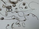 a lot of silver jewelry on a white table