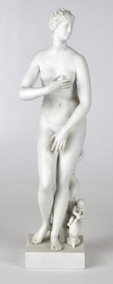 statue d'une femme tenant un chien dans ses bras, posée sur un socle blanc