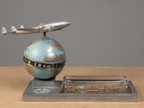 a silver and blue model of a plane on top of a globe