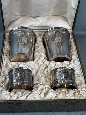 four silver cups in a box on a table