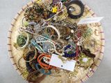 a basket full of assorted jewelry on a table