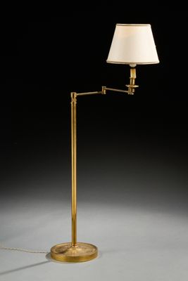 un lampadaire en laiton avec un abat-jour blanc sur fond noir