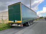 a green semi truck that is parked on the side of the road