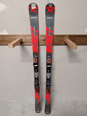 une paire de skis accrochée à un porte-skis en bois dans une pièce