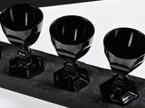 three black cups sitting on a black tray
