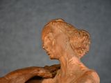 statue of a woman holding a piece of wood in her right hand