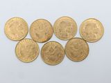 a bunch of gold coins sitting on top of a white surface