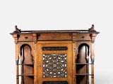 une vieille armoire en bois dont les portes sont ornées de sculptures élaborées