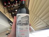a person holding a bottle of wine in front of a wine cooler