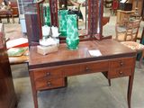 une table sur laquelle se trouvent un miroir et un vase