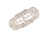 a close up of a silver broochle on a white background
