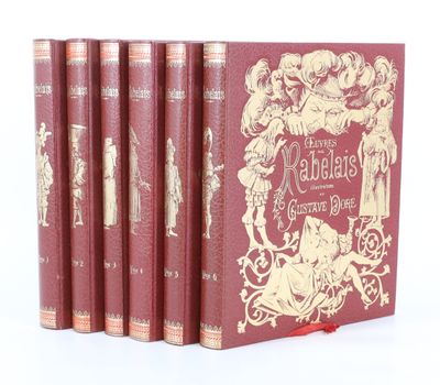 quatre livres rouges ornés d'illustrations dorées, posés sur une surface blanche