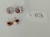 two pairs of earrings and a tag on a white surface