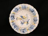 a blue and yellow plate with a bird on it